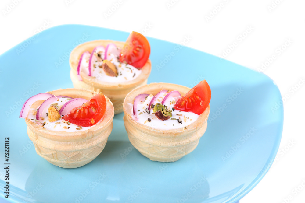 Tartlets with greens and vegetables with sauce on plate