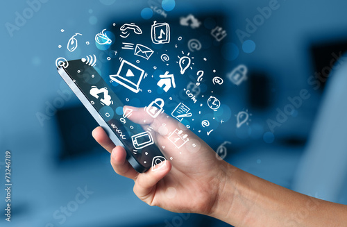 Foto Hand, die Smartphone mit Medienikonen und -symbol hält