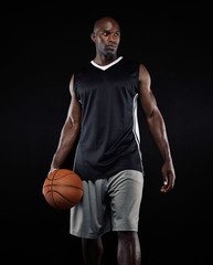 Wall Mural - Portrait of basketball player on black background