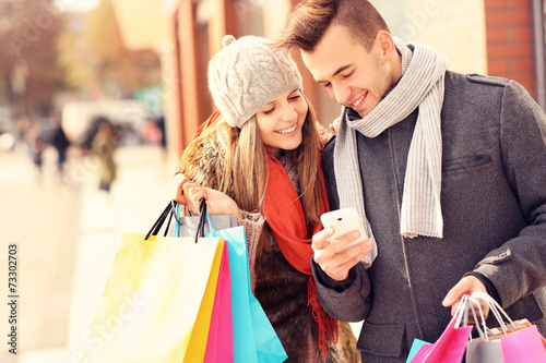 Fotografía Happy couple shopping in the city with smartphone
