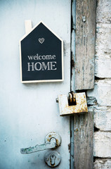 Wall Mural - House Shaped Chalkboard sign on rustic blue door WELCOME HOME