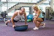 © WavebreakMediaMicro - Female trainer assisting man with push ups at gym