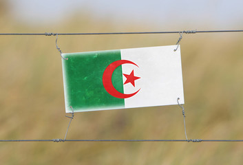 Border fence - Old plastic sign with a flag