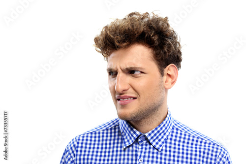 Fotografie, Tablou Portrait of a young disgusted man over white background