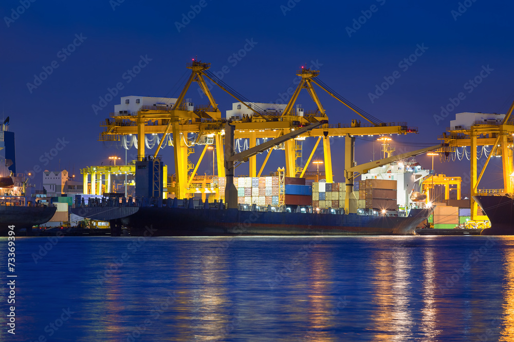 Gantry crane loading and unloading cargo container from cargo ship at ...
