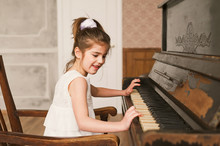 Photo Of A Young Girl Playing The Piano At Home.