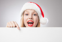 Christmas Woman In Santa Hat Pointing Empty Board
