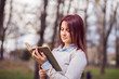 © dinoajan - University girl in park reading a book