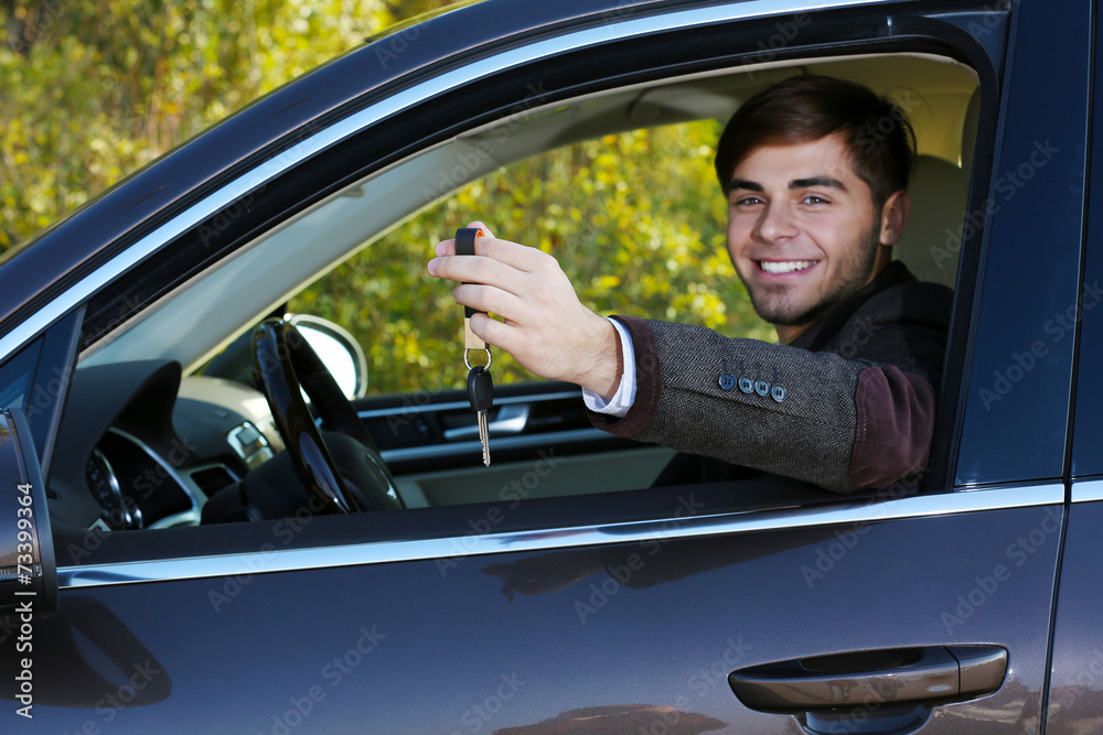Man with car key in car