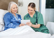 © Tyler Olson - Nurse And Senior Woman Using Tablet PC In Bedroom