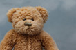 Rustic Old Teddy Bear on grey background