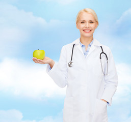 Canvas Print - smiling female doctor with green apple