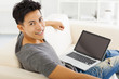 young asian Man sitting in sofa and using  laptop
