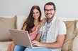 © WavebreakmediaMicro - Hipster couple using laptop on couch
