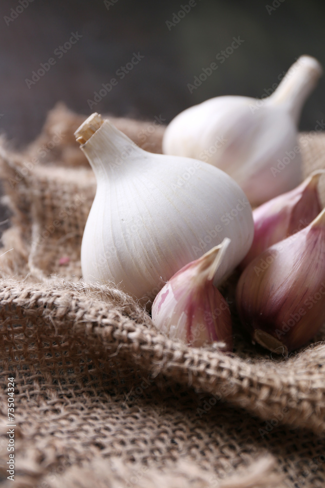 Garlic on sackcloth, on black wooden background