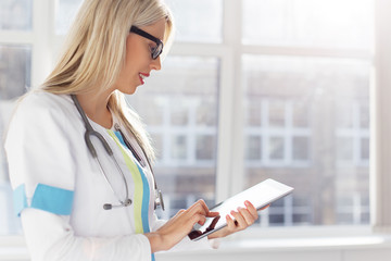 Female doctor looking at medical records on tablet computer