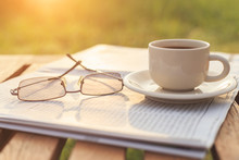 Close Up Glasses On Newspaper And Coffee On The Table In The Mor