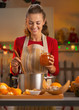 © Alliance - Happy young housewife making orange jam in christmas kitchen