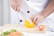 © kungverylucky - Chef's hands cutting yellow bell pepper