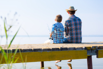 boy and his father fishing togethe