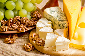 Wall Mural - Cheese, walnuts and grapes on sackcloth