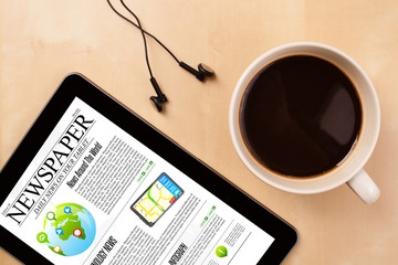 Wall Mural - tablet pc shows news on screen with a cup of coffee on a desk