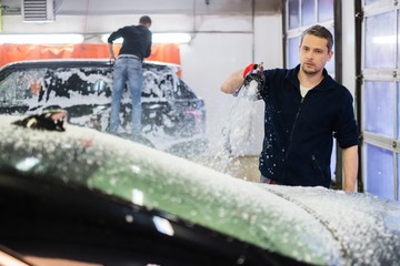 Poster - Man worker washing luxury car on a car wash