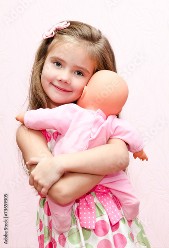 Photographie Cute little girl holding and embracing her doll