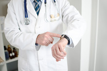 Doctor Showing His Watch With His Finger
