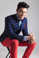 Poster - Happy young fashion man sitting on a stool