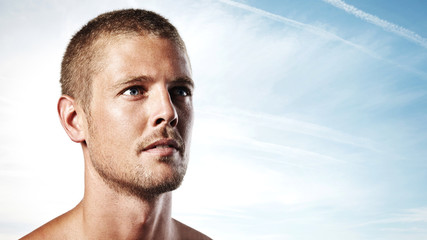 Portrait of an attractive young man on blue sky background