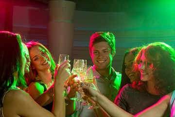 Poster - smiling friends with glasses of champagne in club