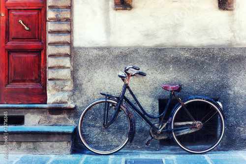 Naklejka na drzwi Vintage bicycle against the wall in front of the door to the hou