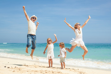 Canvas Print - Happy family jumping on the beach on the day time