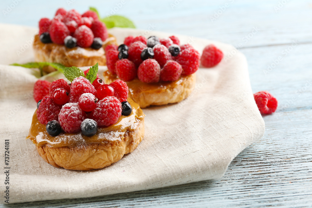 Sweet cakes with berries on table close-up