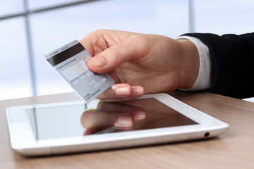 Young business woman  holding  a credit card . On-line shopping