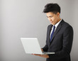 © Tom Wang - young smiling business man using laptop