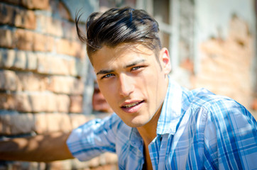 Attractive young man outdoors smiling and looking in camera,