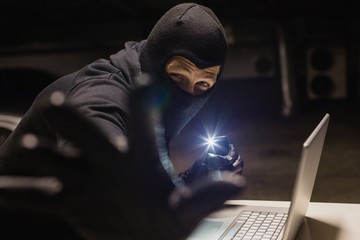 Poster - Robber looking at camera while making light with his phone