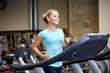 © Syda Productions - smiling woman exercising on treadmill in gym