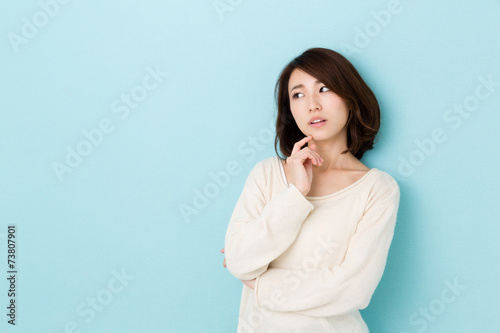 Fotografía attractive asian woman thinking on blue background