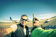 © Mirko Vitali - Hipster young friends taking a selfie at international airport