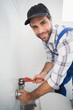 © WavebreakMediaMicro - Plumber fixing tap with wrench