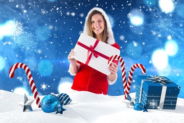 Wall Mural - Composite image of pretty santa girl holding gift