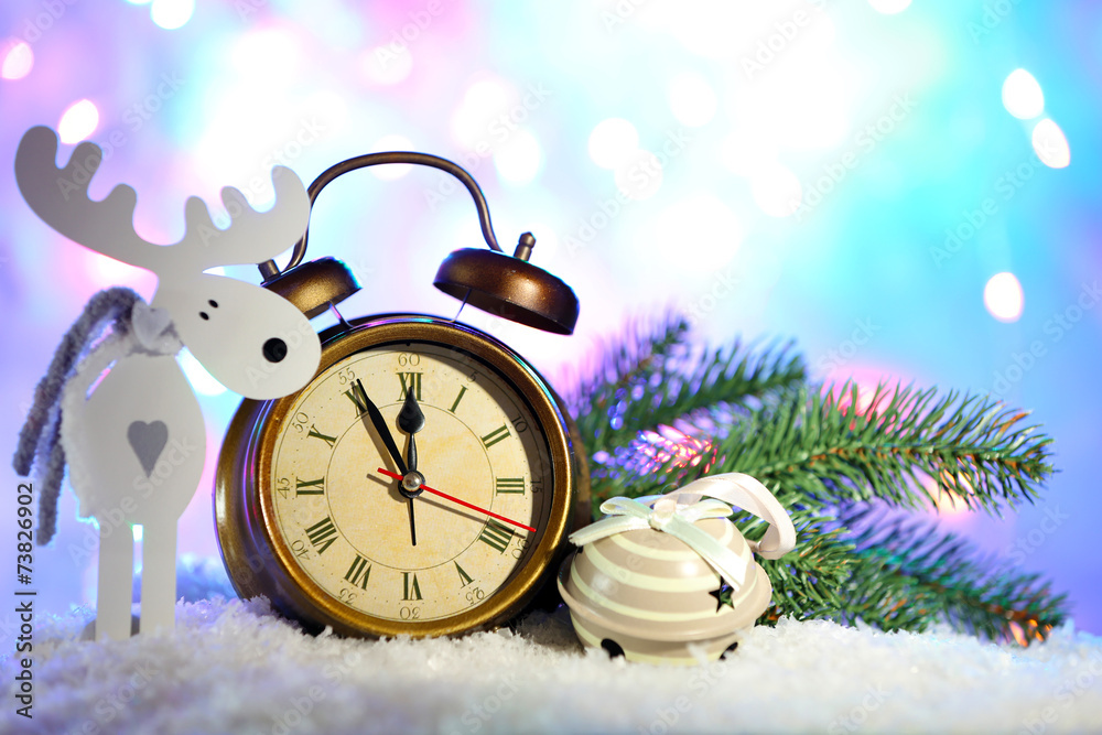 Alarm clock and Christmas decorations in snow