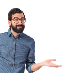 Wall Mural - Young hipster man having doubts over white background