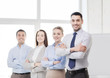 © Syda Productions - smiling businessman in office with team on back