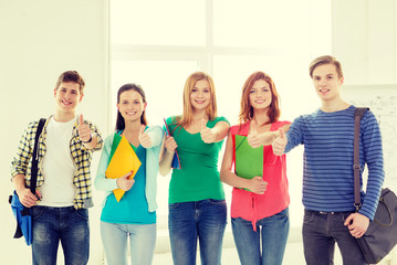 Wall Mural - smiling students with bags and folders at school