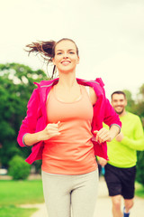 Canvas Print - smiling couple running outdoors