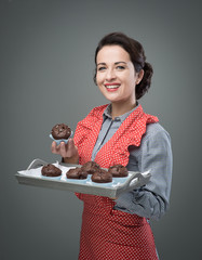 Smiling woman serving chocolate muffins